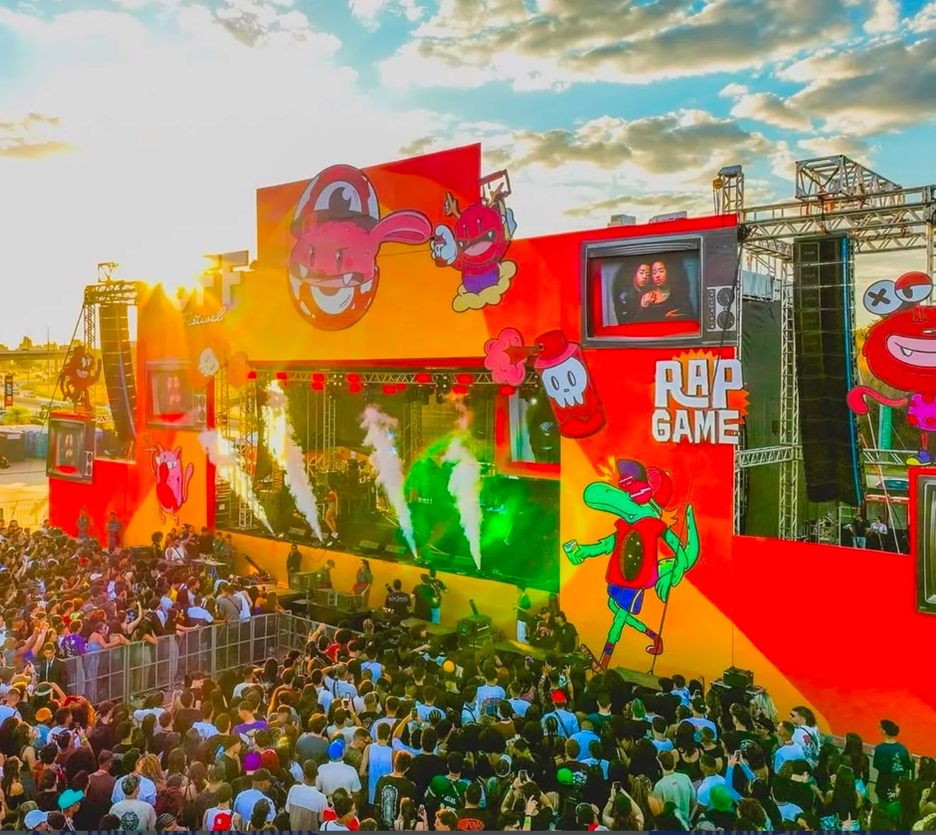 Palco iluminado com público em festival eletrônico